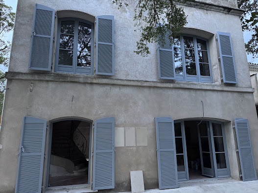 Façade en rénovation avec fenêtres, portes-fenêtres et volets gris bleu